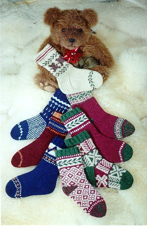 Brown teddy bear holding colorful patterned Christmas stockings on a white background