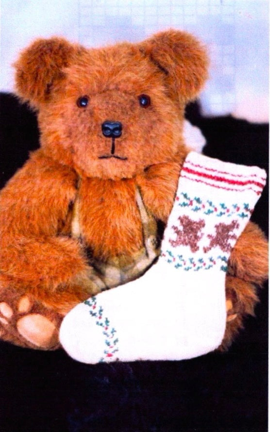 Teddy bear holding socks with teddy bears and holly designs on it
